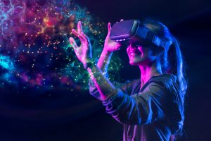 Happy woman with blond hair wearing VR glasses and touching the virtuality in neon lights.