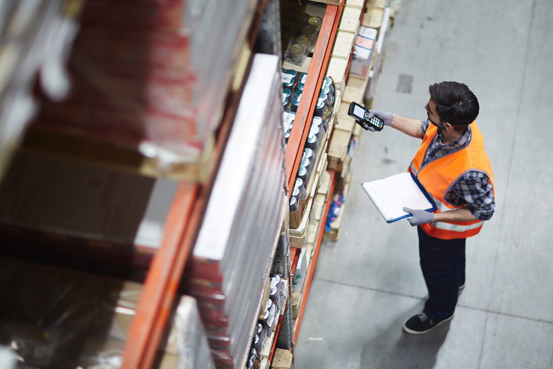 Person checking and scanning barcodes in a storage hall.