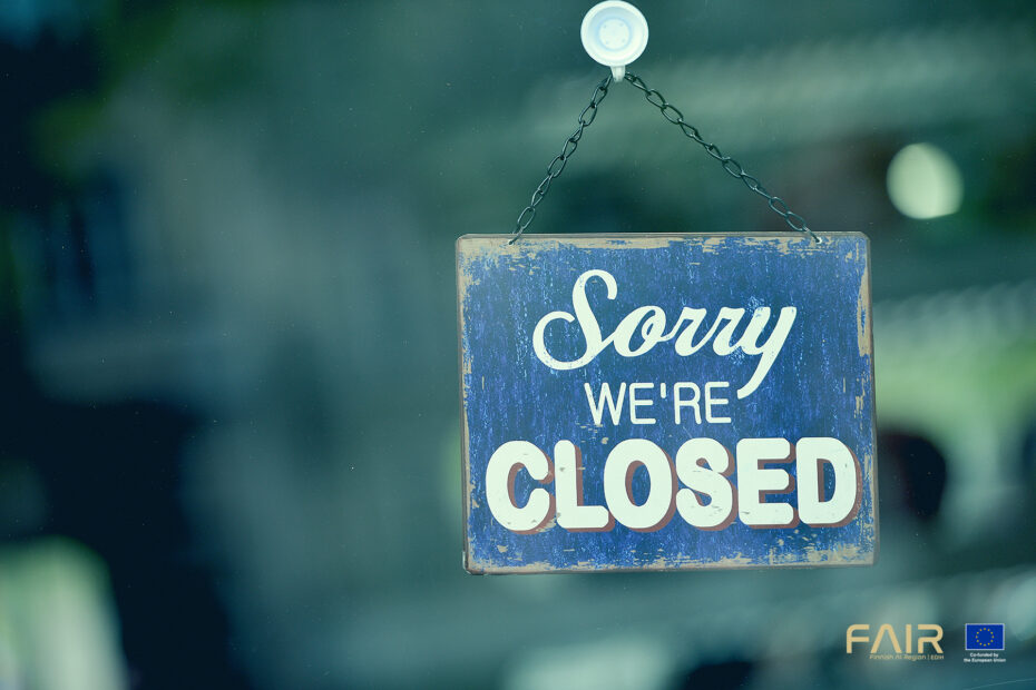 Close-up on a blue closed sign in the window of a shop displaying the message "Sorry we are closed"