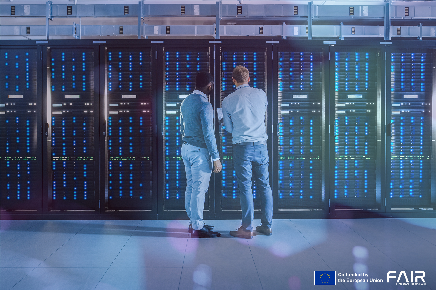 Two people in front of the data center unit.