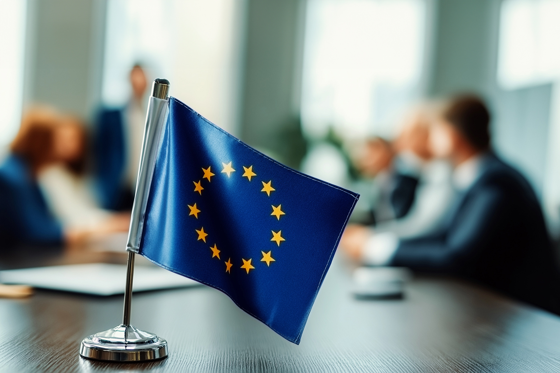 eu flag on a negotation table, blurry people behind