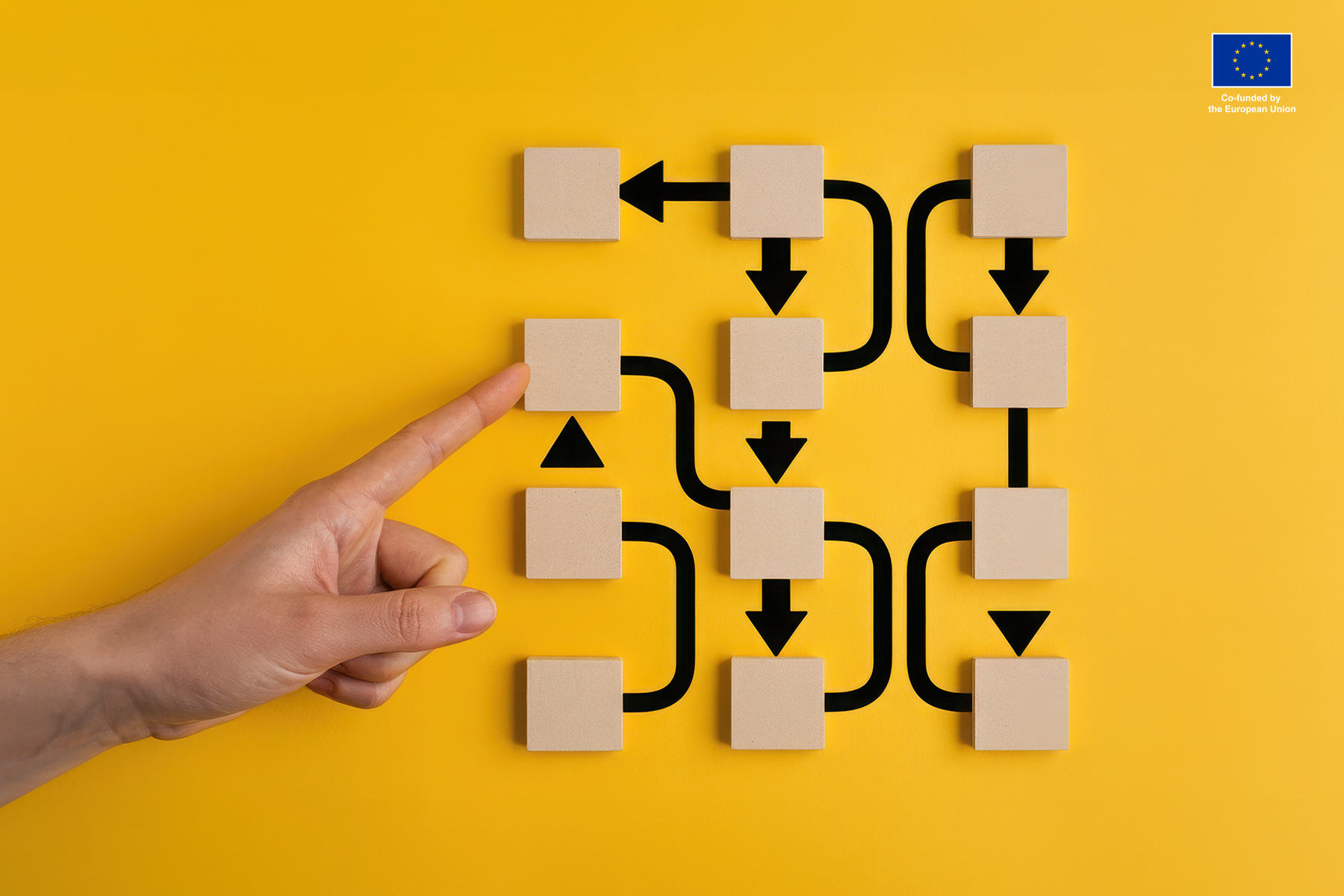 Simple picture of hand pointing to the wooden squares and the complicated system of arrows coming out of them. Representing algorithms.
