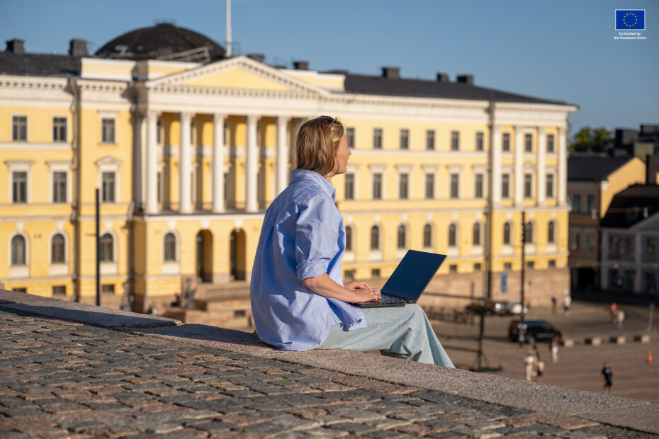 Woman sitting with laptop on the Senate Square in Helsinki