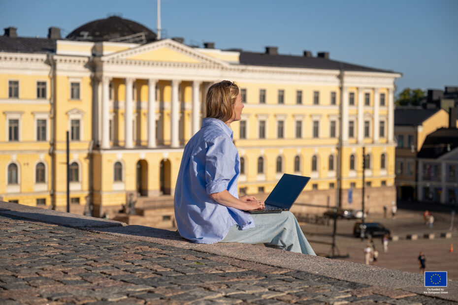 Woman sitting with laptop on the Senate Square in Helsinki