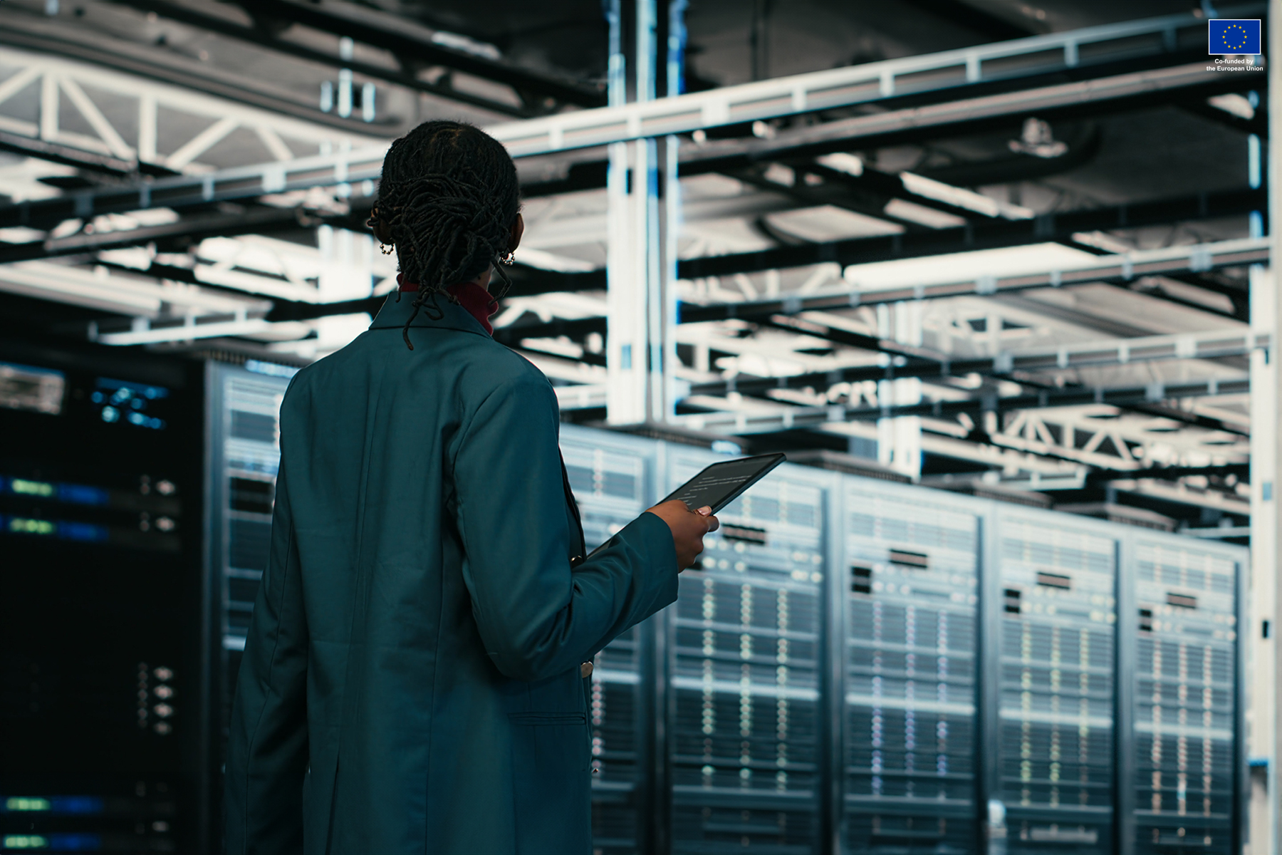 Female programmer walking in data center using tablet to write code, compiling software patches, African American woman in server hub using device application to run programming script, camera B
